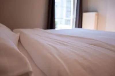 a close up of a white bed with a window at Cozy & Relaxing Apartments-Agia Paraskevi in Athens