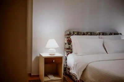 a bedroom with a bed with a lamp on a night stand at Cozy & Relaxing Apartments-Agia Paraskevi in Athens