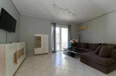 a living room with a couch and a tv at Cozy & Relaxing Apartments-Agia Paraskevi in Athens