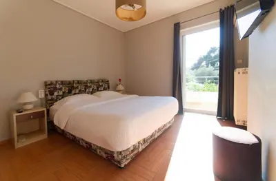 a bedroom with a large bed and a large window at Cozy & Relaxing Apartments-Agia Paraskevi in Athens