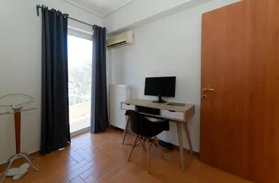 a room with a desk with a computer and a window at Cozy & Relaxing Apartments-Agia Paraskevi in Athens