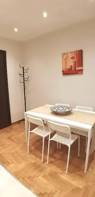 a white dining room table with two chairs and a painting at Modern home, 6' from the Metro in Athens