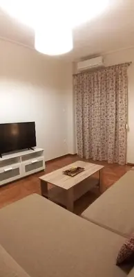 a living room with a television and a coffee table at Modern home, 6' from the Metro in Athens