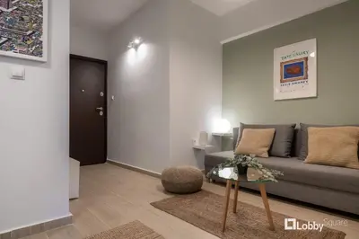 a living room with a couch and a table at Aether Apartment by LobbySquare in Athens