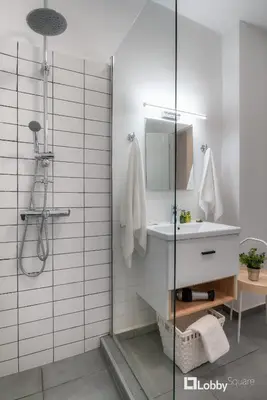 a bathroom with a shower with a sink and a mirror at Aether Apartment by LobbySquare in Athens