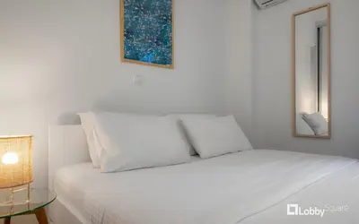 a white bed with white pillows in a room at Aether Apartment by LobbySquare in Athens