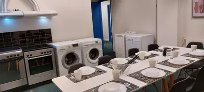 a kitchen with a table with chairs and washing machines at Luxury Apartment 12BD 5BATH in Athens