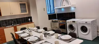 a kitchen with a table and a washing machine at Luxury Apartment 12BD 5BATH in Athens