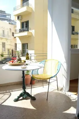 a table and two chairs on a balcony at SUNNY QUIET APATMENT AT LYCABETOUS in Athens