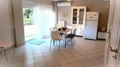 a kitchen with a table and chairs and a refrigerator at Apartment MARE CALMO by the sea. in Porto Rafti