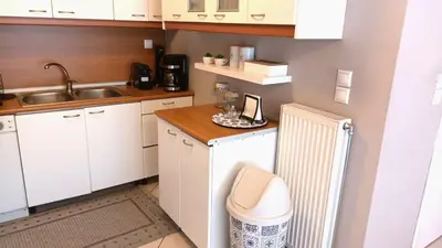a small kitchen with white cabinets and a sink at Apartment MARE CALMO by the sea. in Porto Rafti