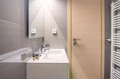 a bathroom with a white sink and a mirror at Athens Innova Apartment I in Athens