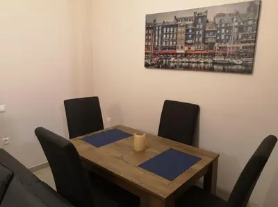 a dining room table with chairs and a candle on it at Athens Innova Apartment I in Athens