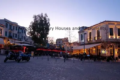 a motorcycle parked on a street in front of buildings at Acropolis Luxury House in Athens