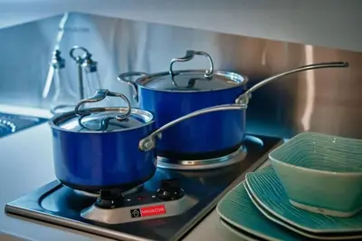 two pots and pans on a stove with plates at Acropolis Luxury House in Athens