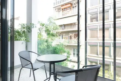 a table and chairs on a balcony with a window at Voda Luxury Residence #301 - Acropolis View Rooftop in Athens