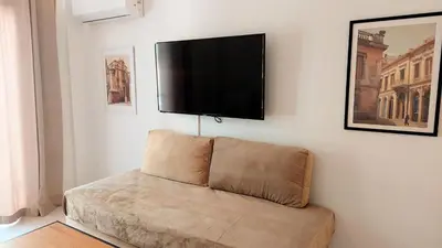 a living room with a couch and a flat screen tv at Wonderful apartment in Acropolis in Athens