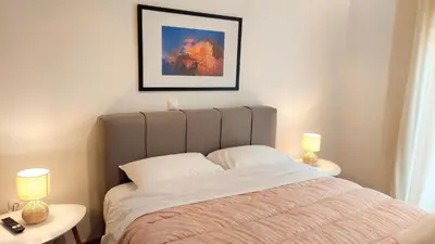 a bedroom with a bed and two tables with lamps at Wonderful apartment in Acropolis in Athens