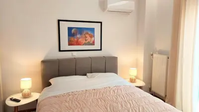 a bedroom with a bed and two tables with lamps at Wonderful apartment in Acropolis in Athens