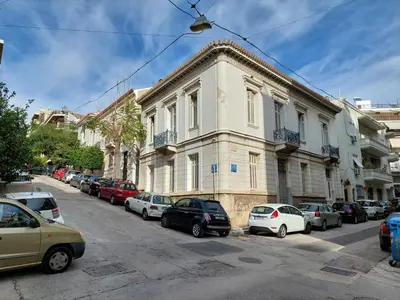 a street with cars parked in front of a building at Wonderful apartment in Acropolis in Athens