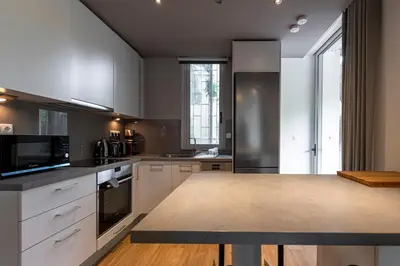a kitchen with white cabinets and a counter top at Phaedrus Living: Luxury Flat Vouliagmeni in Athens
