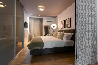 a bedroom with a large bed in a room at Phaedrus Living: Luxury Flat Vouliagmeni in Athens
