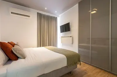 a bedroom with a large bed and a shower at Phaedrus Living: Luxury Flat Vouliagmeni in Athens