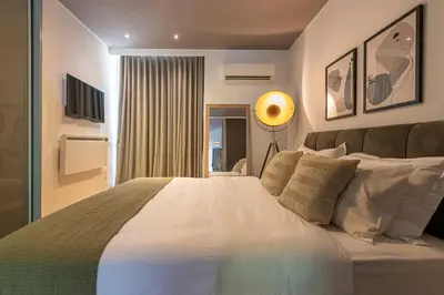 a bedroom with a large white bed and a window at Phaedrus Living: Luxury Flat Vouliagmeni in Athens