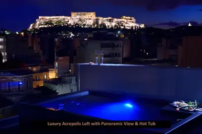 a view of the acropolis lit up at night at ATER ALBUS by K&K in Athens