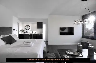 a bedroom with a large white bed and a kitchen at ATER ALBUS by K&K in Athens