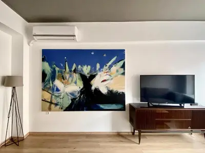 a living room with a large painting on the wall at Mosaikon Guesthouses #Nikiou Str in Athens