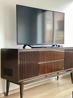 a flat screen tv on top of a wooden entertainment center at Mosaikon Guesthouses #Nikiou Str in Athens