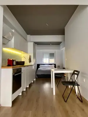 a kitchen with a table and a bed in a room at Mosaikon Guesthouses #Nikiou Str in Athens