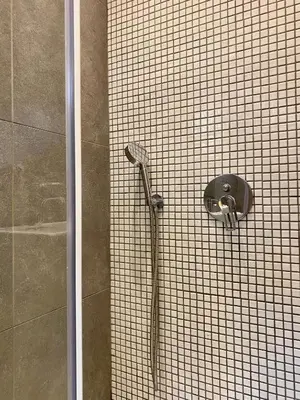 a shower in a bathroom with a tiled wall at Mosaikon Guesthouses #Nikiou Str in Athens