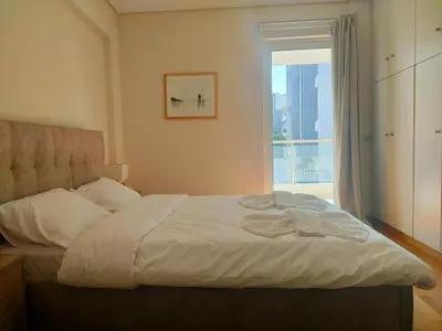 a bedroom with a large bed with a window at Alimos seaview apartment in Athens