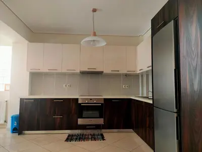 a kitchen with wooden cabinets and a refrigerator at Alimos seaview apartment in Athens