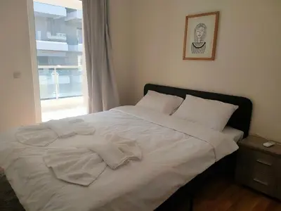 a white bed with white pillows and a window at Alimos seaview apartment in Athens