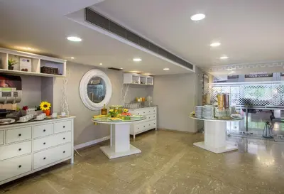 a large kitchen with white cabinets and a mirror at Airotel Parthenon in Athens