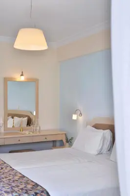 a bedroom with a white bed and a mirror at Airotel Parthenon in Athens