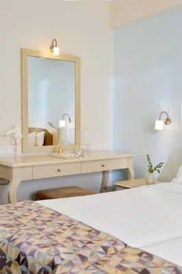 a bedroom with a desk with a mirror and a bed at Airotel Parthenon in Athens