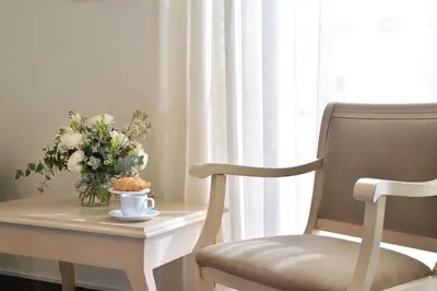 a table with a vase of flowers and a chair at Airotel Parthenon in Athens