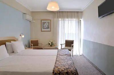 a hotel room with two beds and a television at Airotel Parthenon in Athens