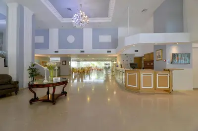 a hospital lobby with a table and a chandelier at Airotel Parthenon in Athens