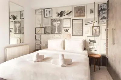 a bedroom with a white bed with pictures on the wall at Luxury Apartment near Acropolis-Living Stone Gold in Athens