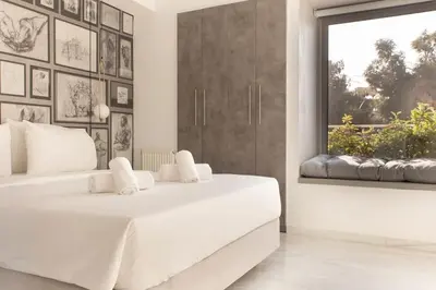 a white bedroom with two beds and a window at Luxury Apartment near Acropolis-Living Stone Gold in Athens