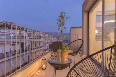 a balcony with two chairs and a table on a building at Luxury Apartment near Acropolis-Living Stone Gold in Athens
