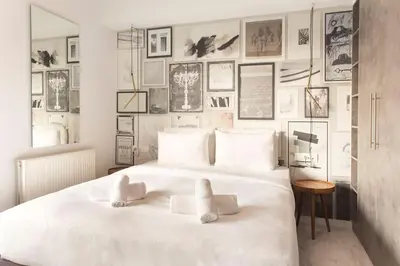 a bedroom with a white bed with pictures on the wall at Luxury Apartment near Acropolis-Living Stone Gold in Athens