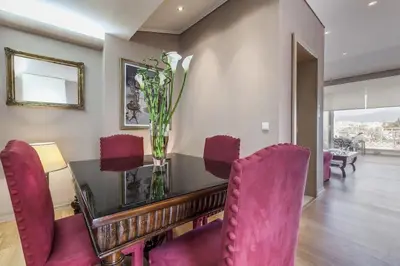 a dining room with a table and red chairs at Luxury Acropolis View Duplex Penthouse in Thiseio 155m2 in Athens