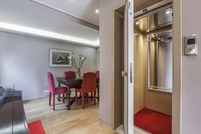 a dining room with a table and red chairs at Luxury Acropolis View Duplex Penthouse in Thiseio 155m2 in Athens