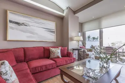 a living room with a red couch and a table at Luxury Acropolis View Duplex Penthouse in Thiseio 155m2 in Athens